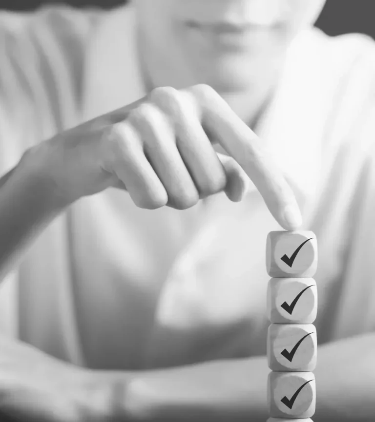4 atouts d'ExcelHum Une main empile des cubes marqués d'une coche sur une table.